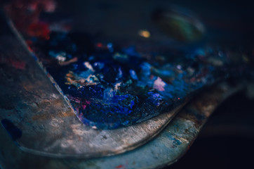 Many of artists palettes with different pain colours. Beautiful dark blue colours on the top closeup