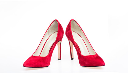 Shoes made out of red suede on white background, isolated. Footwear for women with thin high heels. Elegant stiletto shoes concept. Pair of fashionable high heeled pump shoes.