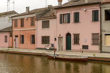 bike, boat and old houses in san Pietro district, Comacchio, Italy