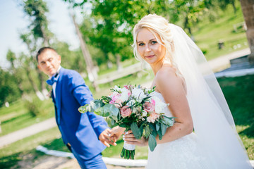 Bride and groom at wedding Day walking Outdoors on spring nature. Bridal couple, Happy Newlywed...