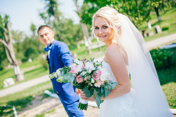 Bride and groom at wedding Day walking Outdoors on spring nature. Bridal couple, Happy Newlywed...