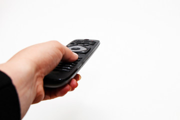 Female hand holding a remote for a TV set on a white background