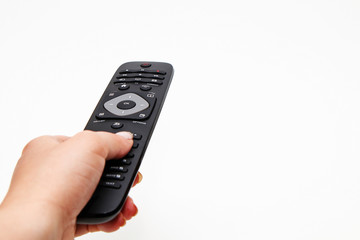 Female hand holding a remote for a TV set on a white background