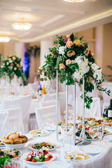 Wedding Banquet hall decorated with flowers. Wedding decor, table setting, floral arrangements in the restaurant.