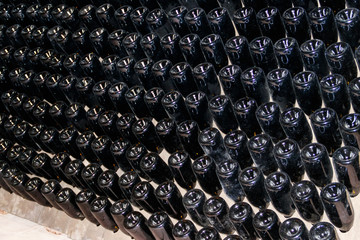 Many wine bottles in wine cellar of winery
