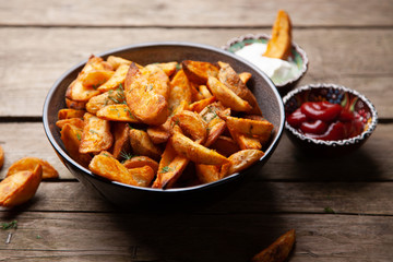Baked potato fries on wooden table