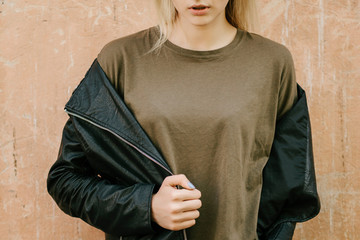 Beautiful young blonde girl  in a blank green military T-shirt and Leather Jacket  with jeans 