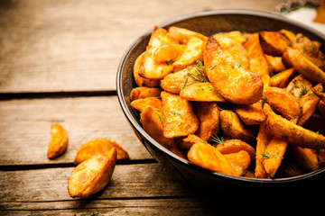 Baked potato fries on wooden table