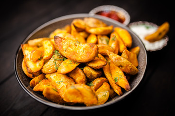 Baked potato fries on wooden table