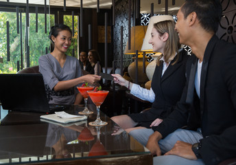 Couple and receptionist at counter in hotel. Checking in in hotel concept