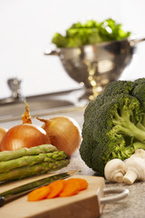 FRESH LETTUCE BROCOLLI CARROTS ASPARAGUS AND ONIONS ON KITCHEN WORKTOP