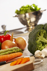 FRESH LETTUCE BROCOLLI CARROTS ASPARAGUS RED PEPERS AND ONIONS ON KITCHEN WORKTOP