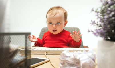 Happy child baby girl toddler sitting with keyboard of computer isolated on a white background