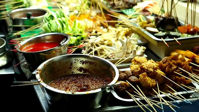 People cooking, selling and buying Asian street Food. Exotic Asian (Thai, Malaysian, Chinese, Korean, Japanese) Food. Exotic delicious Street food, especially seafood are very popular among tourists