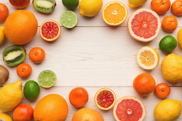 Assorted citrus fruits on white wooden planks, top view