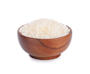 Uncooked dry rice in wooden bowl isolated