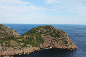 Steep, rocky cliffs along the coastline, St. John's, Newfoundland Labrador, Canada. Panoramic view of the ocean and hilly coastline.