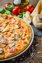 Italian pizza and ingredients on wooden table