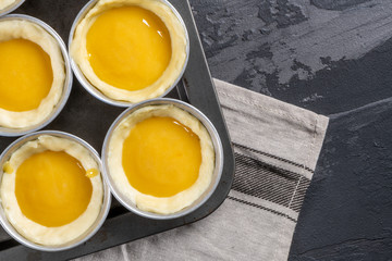 Traditional portuguese dessert pastel de nata before going to the oven. Dough of custard egg tarts
