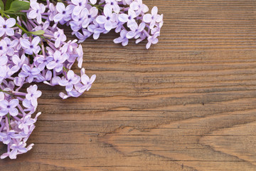 Fototapeta na wymiar Fresh flowers frame of purple Lilac flowers on wooden background