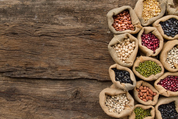 Legumes seed in sack on wooden background, top view. Protein from bean is best nutrition for vegan...