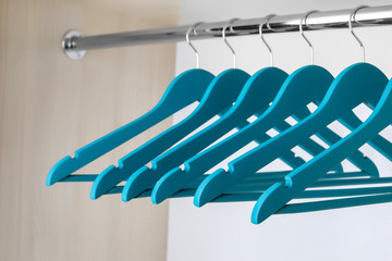 Clothes hangers on metal rail in wardrobe