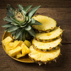 pineapple on dish slice on old wood