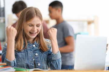 Teenage girl doing homework in classroom