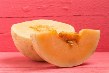 melon (sunlady) slice. half. on wood pink