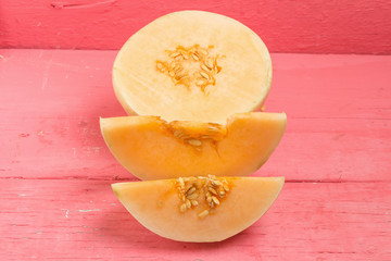 melon (sunlady) slice. half. on wood pink