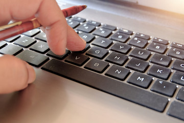 Man's hands typing on a laptop keyboard.