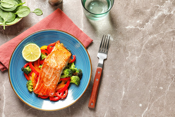 Plate with tasty cooked salmon and vegetables on table, top view