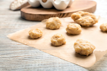 Pieces of fresh raw dough on wooden table