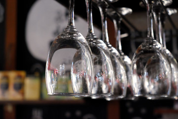 Glasses of wine hanging above a bar rack in restaurant.