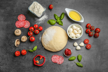 Fototapeta na wymiar Flat lay composition with raw dough and ingredients for pizza on grey background