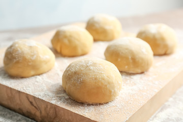 Fototapeta na wymiar Fresh raw dough with flour on wooden board