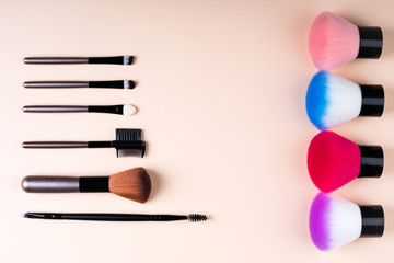 Cosmetics accessories for makeup on beige background flat lay. Set of cosmetics brushes. Minimal composition. Fashion and beauty blogging concept. Top view, copy space