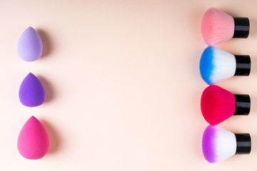 Cosmetics accessories for makeup on beige background flat lay. Set of cosmetics brushes. Minimal composition. Fashion and beauty blogging concept. Top view, copy space