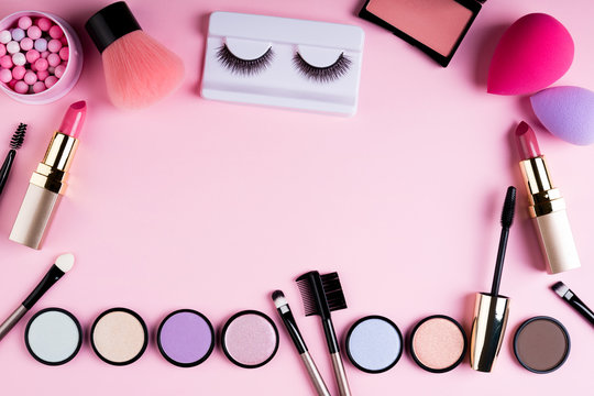 Makeup products and decorative cosmetics on pink background flat lay. Fashion and beauty blogging concept. Top view, copy space