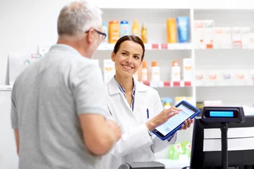 Tuinposter medicine, healthcare and technology concept - happy apothecary and senior male customer with digital prescription on tablet pc computer screen at pharmacy © Syda Productions
