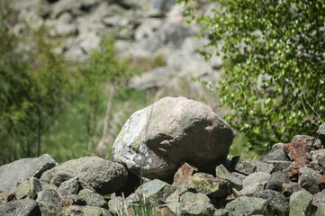 Different types of stones closeup piled on green grass background on sunny day