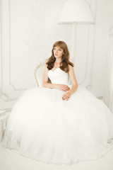 Fototapeta premium Gorgeous bride in robe posing and preparing for the wedding ceremony face in a room