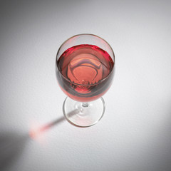 SINGLE GLASS OF ROSE WINE ON WHITE BACKGROUND