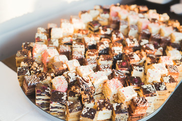 Delicious and tasty dessert table with cupcakes shots at reception closeup