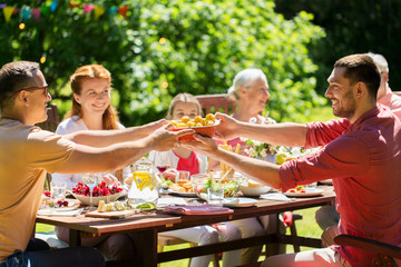 leisure, holidays and people concept - happy family having festive dinner or summer garden party