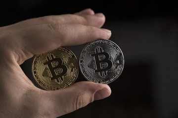 Fototapeta na wymiar A man holding a bitcoins on black background