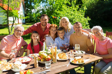 leisure, holidays and people concept - happy family having festive dinner or summer garden party