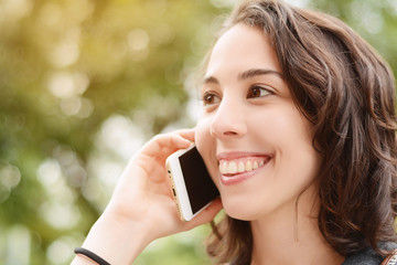 Young beautiful woman talking with her smartphone