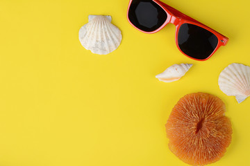 Top view of sunglasses, shells, starfish and sunblock