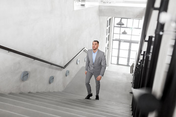 business, success and career lift concept - businessman walking upstairs